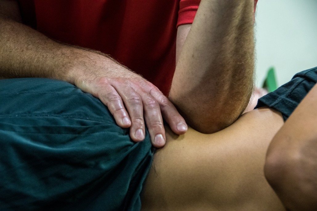 Soft tissue work to the muscles of the low back in an athlete with low back pain.