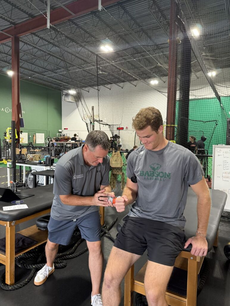 Lenny Macrina testing strength in a college baseball pitcher at Champion PT and Performance